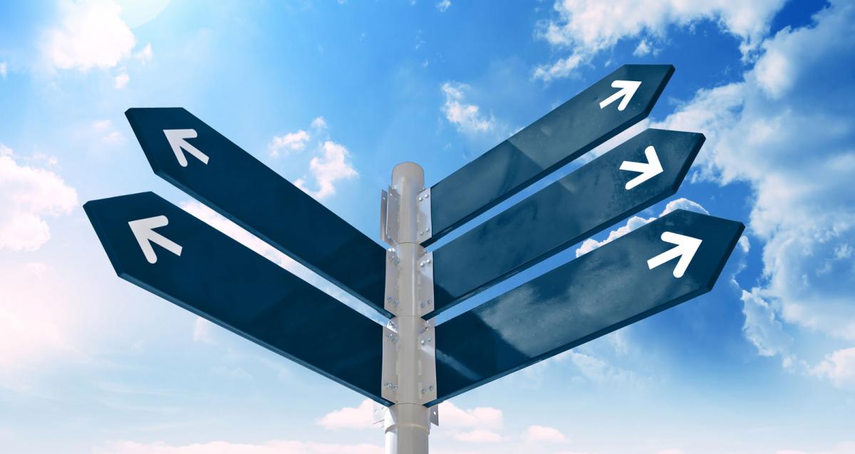 Blank signpost with arrows over blue sky
