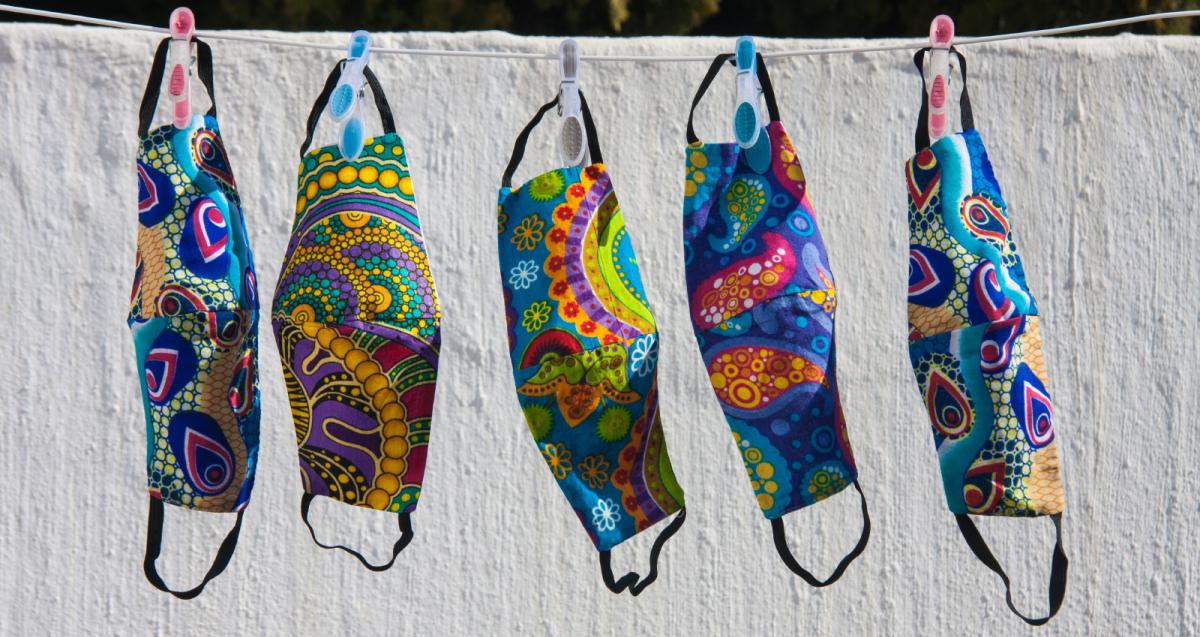 Colorful South African fabric face masks for Covid-19 protection hanging out to dry on a clothesline. Photo: Kelly Ermis/Shutterstock