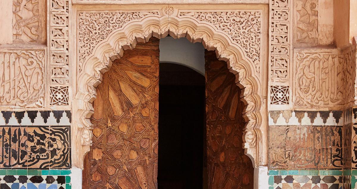 Carving oriental stone wall and carving wooden arch door Marrakech, Morocco