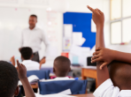Kids raising hands to answer teacher at an elementary school lesson